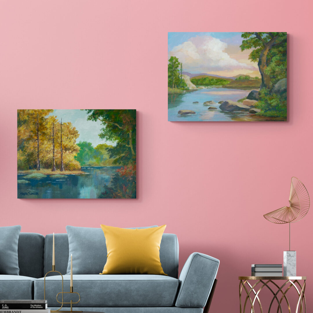 Two local fine art paintings hanging on a wall in a living room.